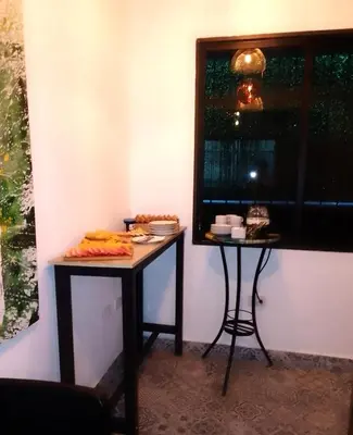 two tables in the corner of a room with a window at Hotelito Bonito Eli & Edw in Santo Domingo