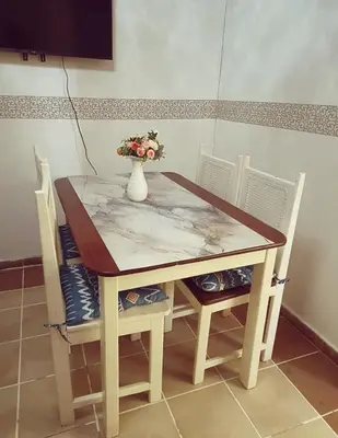 a table with two chairs and a vase with flowers on it at Cozy & Spacious Apartament Boca Chica Beach in Boca Chica