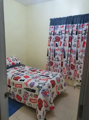 a bedroom with a bed with a comforter and curtains at Villa Privada con Piscina a Minutos del Aeropuerto de Santo Domingo in Boca Chica