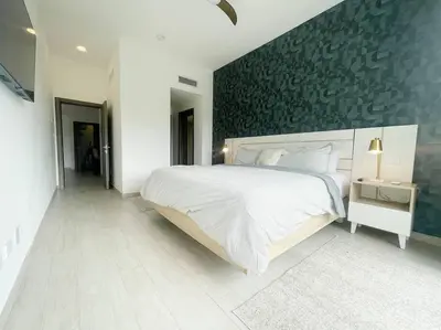 a bedroom with a large white bed and a wall at Caribbean Retreat at Cana Bay Golf Residence in Punta Cana
