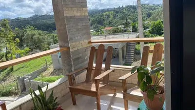 a pair of chairs sitting on a balcony with a view at Apartamentos JGB in Sosúa Abajo
