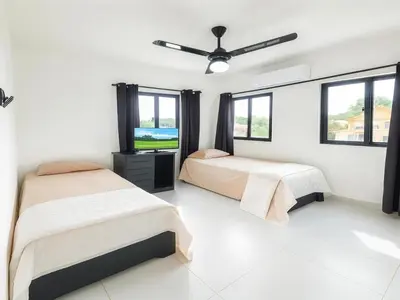 a bedroom with two beds and a ceiling fan at Modern 3 Bedroom Penthouse Apartment with Free Parking in San Felipe de Puerto Plata