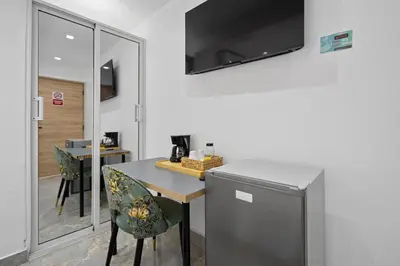 a kitchen with a table and chairs in a room at Hotel Vista Caribe Azúa in Azua de Compostela