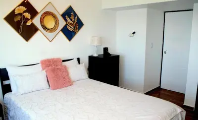 a bedroom with a white bed with two pillows at Sturning Ocean View. in Santo Domingo