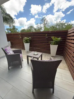 a patio with chairs and a table and a fence at Blue Coast Apartment - Vibe Dominicus in La Laguna