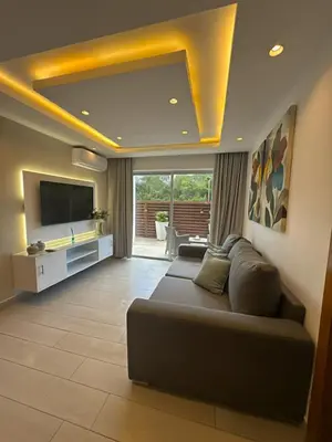 a living room with a couch and a flat screen tv at Blue Coast Apartment - Vibe Dominicus in La Laguna