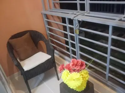 a chair and a vase with flowers on a table at Hermoso condominio con aparcamiento gratuito in La Javilla