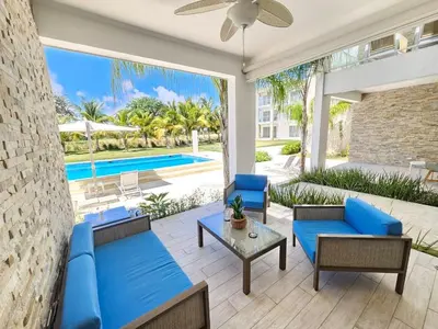 a patio with blue furniture and a swimming pool at Comfort Condo w/Pool View at Hard Rock Golf Course in Punta Cana