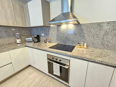 a kitchen with white cabinets and a stove top oven at Comfort Condo w/Pool View at Hard Rock Golf Course in Punta Cana