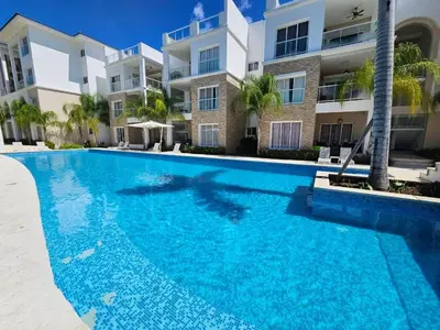 a swimming pool in front of a building at Comfort Condo w/Pool View at Hard Rock Golf Course in Punta Cana