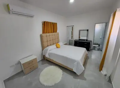 a bedroom with a white bed and a mirror at Umbrella Street, city Center, close to many atracctions in San Felipe de Puerto Plata