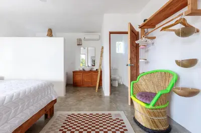 a bedroom with a bed and a green basket at Casa flor - 16 pax, vista al mar, 2 min de la playa in Las Galeras