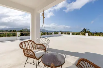 a patio with chairs and a table on a roof at Casa flor - 16 pax, vista al mar, 2 min de la playa in Las Galeras