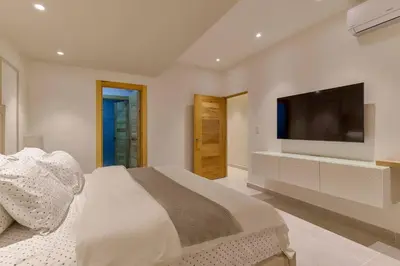 a bedroom with a large bed and a flat screen tv at Oasis Urbano Family 2br Pool Gym Lm22-8B in Santo Domingo