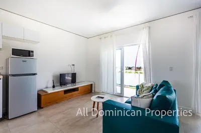 a living room with a blue couch and a refrigerator at Ocean Villas, Campo Del Mar in Sosúa