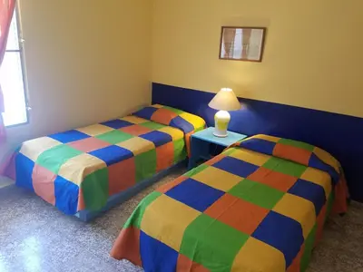 a bedroom with two beds and a table with a lamp at Casa Sylvie in Sosúa
