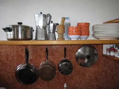 a bunch of pots and pans hanging on a shelf at Casa Sylvie in Sosúa