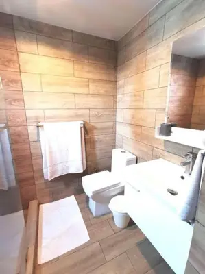 a bathroom with two sinks and a toilet and a mirror at Stylish 1br Apt in Piantini/Serralles, Santo Dgo in Santo Domingo
