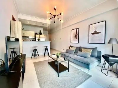a living room with a blue couch and a kitchen at Stylish 1br Apt in Piantini/Serralles, Santo Dgo in Santo Domingo