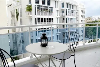 a white table and chairs on a balcony at Stylish 1br Apt in Piantini/Serralles, Santo Dgo in Santo Domingo
