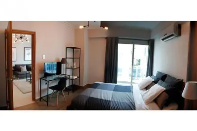 a bedroom with a bed and a desk and a window at Stylish 1br Apt in Piantini/Serralles, Santo Dgo in Santo Domingo