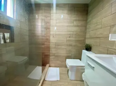 a bathroom with a toilet and a tub and a sink at Stylish 1br Apt in Piantini/Serralles, Santo Dgo in Santo Domingo