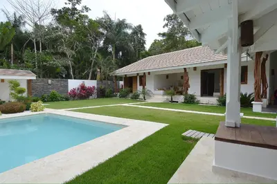 a backyard with a swimming pool and a house at Seaside villa with housekeeping staff - Las Terrenas in Las Terrenas