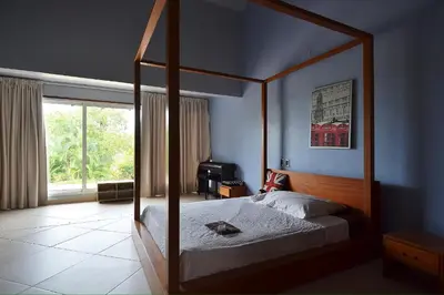 a bedroom with a canopy bed and a window at Seaside villa with housekeeping staff - Las Terrenas in Las Terrenas