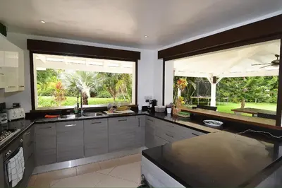 a kitchen with two large windows and a counter top at Seaside villa with housekeeping staff - Las Terrenas in Las Terrenas