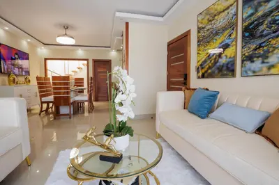 a living room with a white couch and a glass table at Luxury Penthouse in San Francisco de Macorís