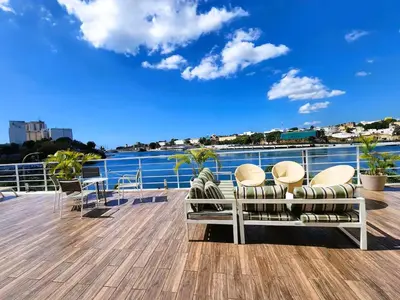 a deck with chairs and a view of the water at Luxury Riviera Colonial, Santo Domingo in Santo Domingo