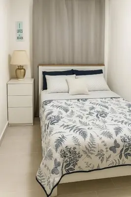 a bedroom with a bed with a blue and white comforter at Luxury Riviera Colonial, Santo Domingo in Santo Domingo