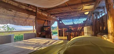 a bedroom with a bed and a view of a field at Mini Lodge in Cabarete