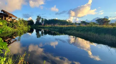 a river with a reflection of clouds in the water at Mini Lodge in Cabarete