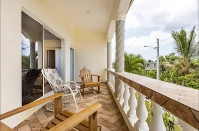 a house with a balcony with a rocking chair at Casa Mami in Río San Juan