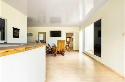 a living room with white walls and a wooden floor at Casa Mami in Río San Juan