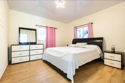a bedroom with a bed and two dressers and a mirror at Casa Mami in Río San Juan