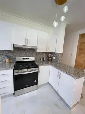 a kitchen with white cabinets and a black stove at Torre Sophia Monserrat in Los Frailes