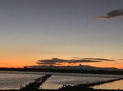 a sunset over a body of water with a pier at Casa Zanelli, lugar de paz… in Baní