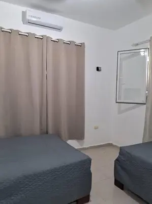 a bedroom with two beds and a window with curtains at Casa Zanelli, lugar de paz… in Baní