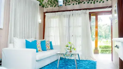 a living room with a white couch and a blue rug at Guacamayos Hotel in Bonao