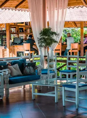 a living room with a couch and a table and chairs at Guacamayos Hotel in Bonao