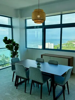 a dining room with a table and chairs and windows at Juan Dolio, Beach Access 2 BR Apt Salitre Tower front of Club Hemingway in Juan Dolio