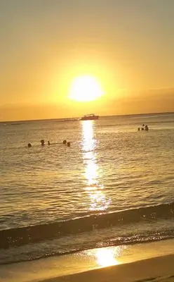 a group of people swimming in the ocean at sunset at Acogedor apartamento en Estrella Dominicus in La Laguna