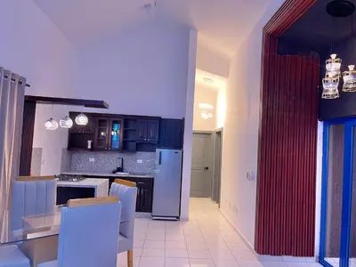 a kitchen with a refrigerator and a table and chairs at Villas Carela in Cabarete