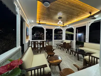 a porch with chairs and couches and tables at Villas Carela in Cabarete
