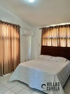 a bedroom with a bed with a wooden headboard and curtains at Villas Carela in Cabarete