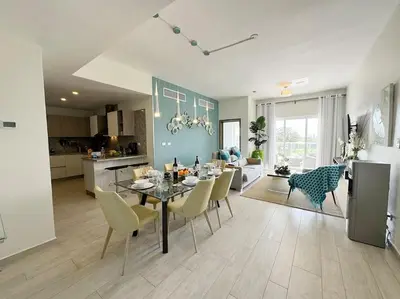 a dining room and living room with a table and chairs at Cana Pearl Penthouse, Hard Rock Golf & Casino in Punta Cana