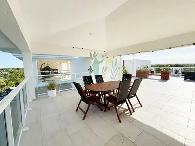 a dining room with a table and chairs on a balcony at Cana Pearl Penthouse, Hard Rock Golf & Casino in Punta Cana
