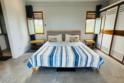 a bedroom with a bed with blue and white stripes at Private Garden Villa With Parking in Las Terrenas